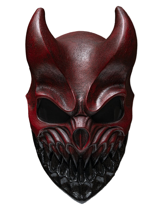 A red and black devil mask with horns, hollow eyes, and a sharp, toothy grin, shown against a plain white background.